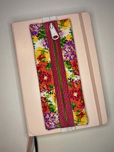 Floral journal case with pink zipper binding and white zipper pull - featured on a journal.